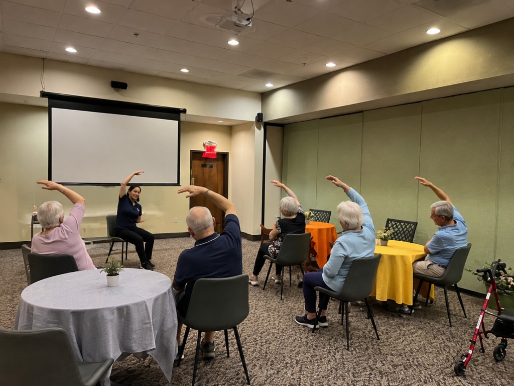 Residents participating in a guided exercise and wellness class